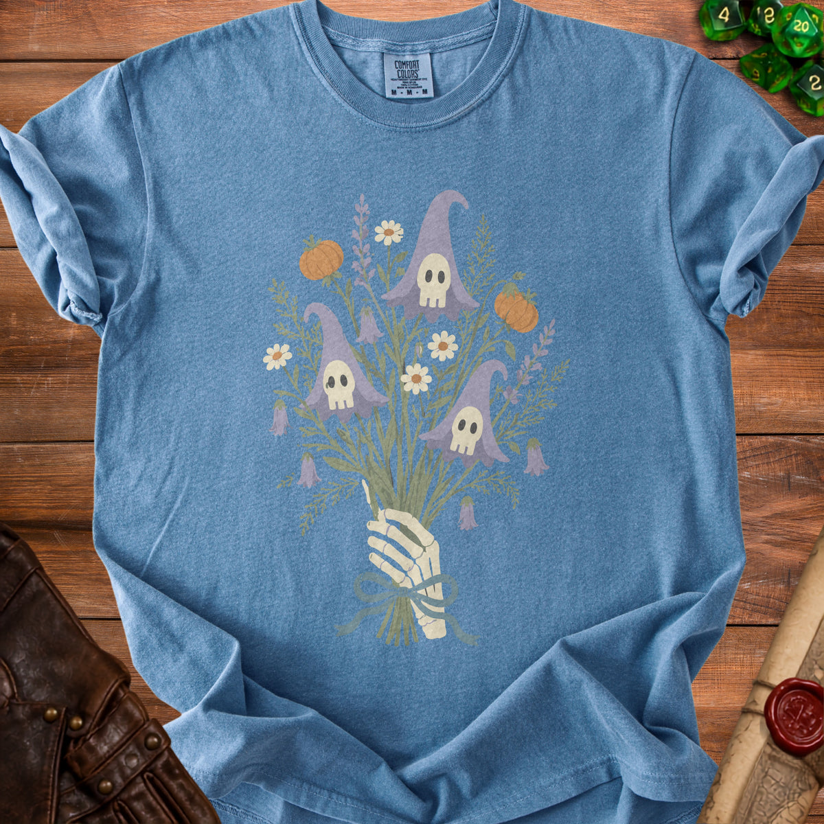 Skeleton hand holding a bouquet of witch hats with skulls, pumpkins, and flowers.