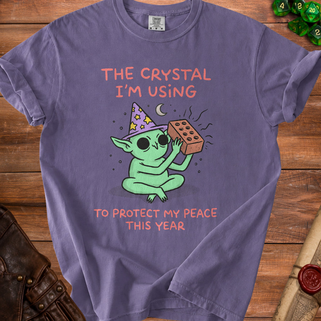 Green creature with wizard hat holding brick, text "The Crystal I'm Using to Protect My Peace This Year."