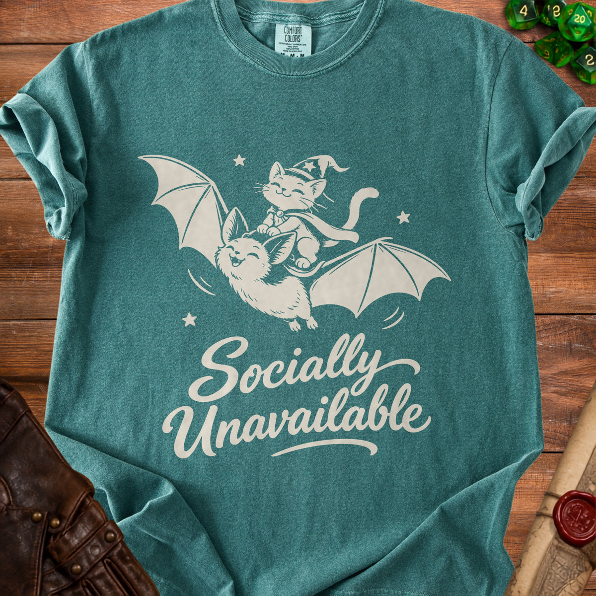 Green t-shirt with white graphic of cat on bat and text "Socially Unavailable".