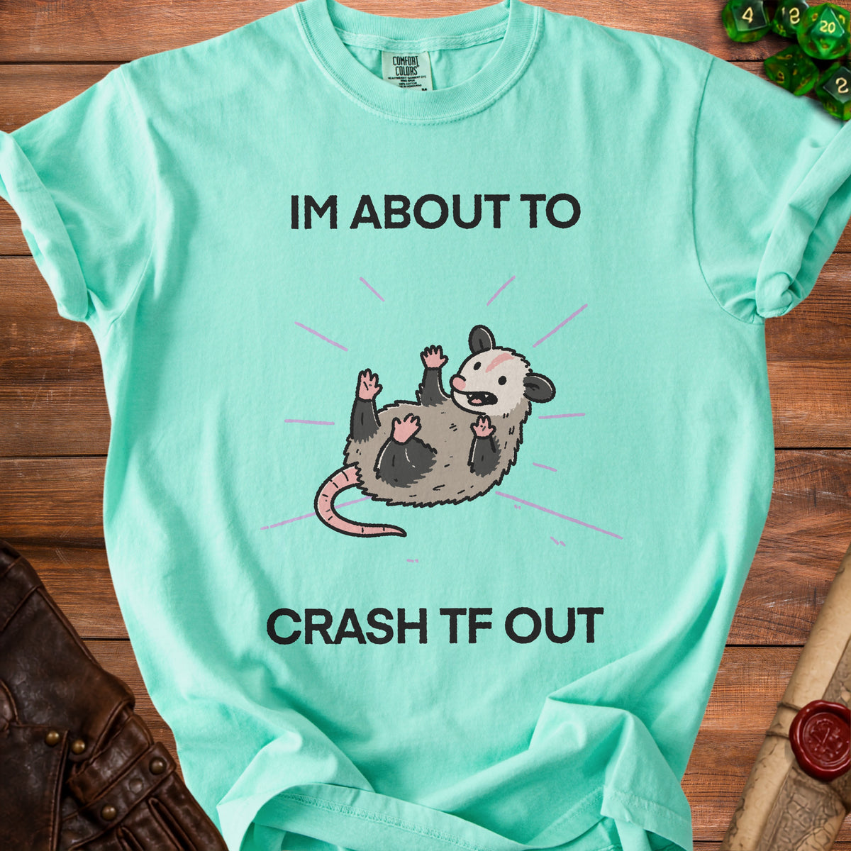 Aqua t-shirt with opossum graphic and "IM ABOUT TO CRASH TF OUT" text.