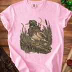 Pink t-shirt with a graphic of a hooded duck archer holding a bow and arrows.