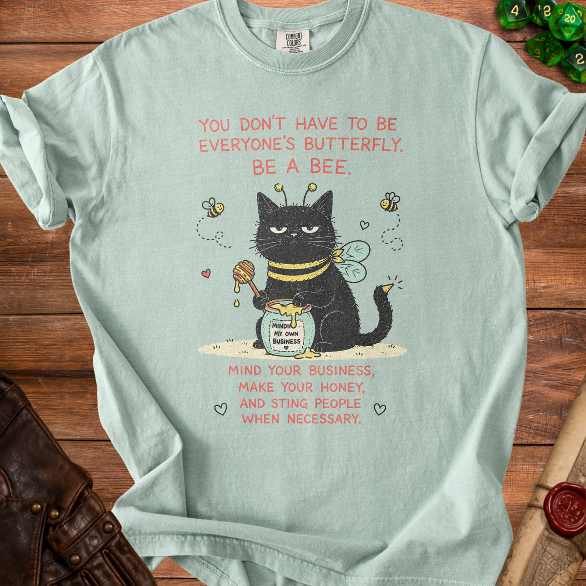Light blue t-shirt with a black cat dressed as a bee and text.