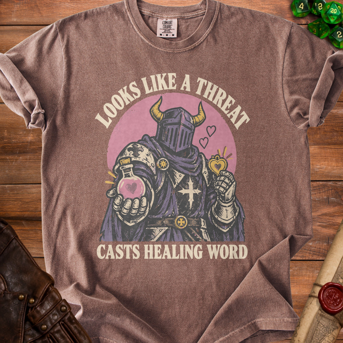 T-shirt graphic of a knight holding a potion and a heart, with text "Looks like a threat casts healing word".