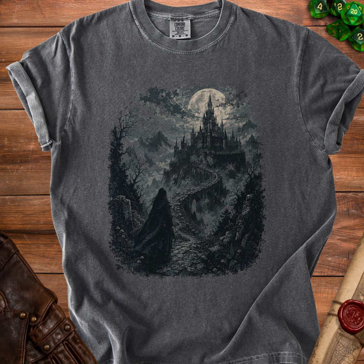 Dark t-shirt with a graphic of a cloaked figure approaching a haunted castle under a full moon.