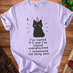 Lavender t-shirt with a black cat wearing a party hat and the text "I've tasted 9-5 and I've tasted unemployment I recommend not being born".