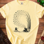 Yellow t-shirt with black graphic of a goblin, treasure chest, and bats swirling around trees.