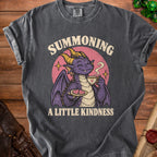 T-shirt graphic: purple dragon holding tea and cookies, text reads "SUMMONING A LITTLE KINDNESS".