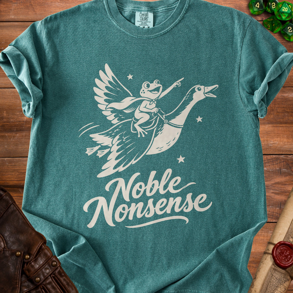 A teal t-shirt featuring a graphic of a frog riding a flying goose with the text Noble Nonsense.