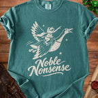 A teal t-shirt featuring a graphic of a frog riding a flying goose with the text Noble Nonsense.