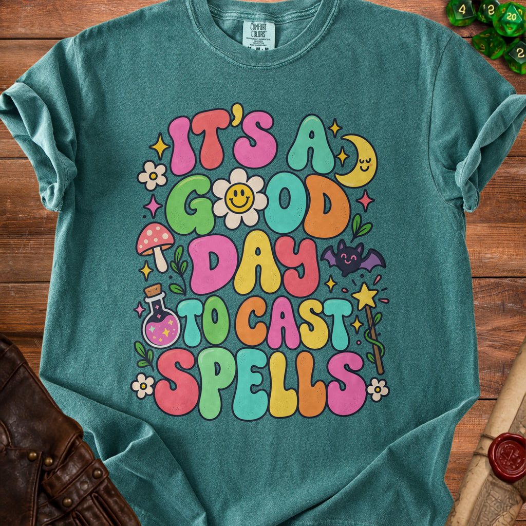 Teal t-shirt with colorful groovy text that reads "It's a good day to cast spells."