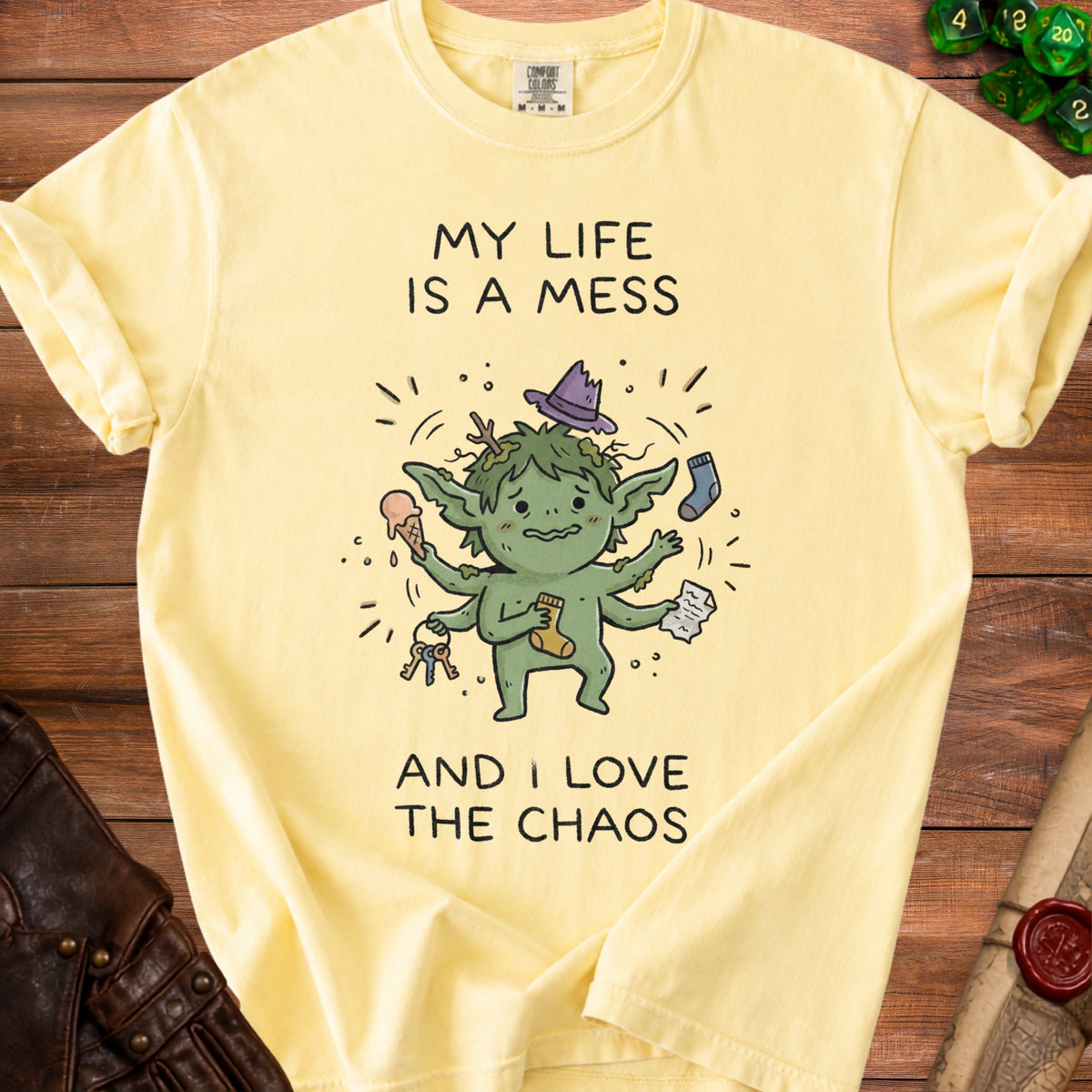 Yellow t-shirt with illustration of a green, multi-armed creature and text "MY LIFE IS A MESS AND I LOVE THE CHAOS".