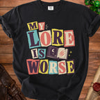 Black t-shirt with "MY LORE IS WORSE" text and an open book graphic.