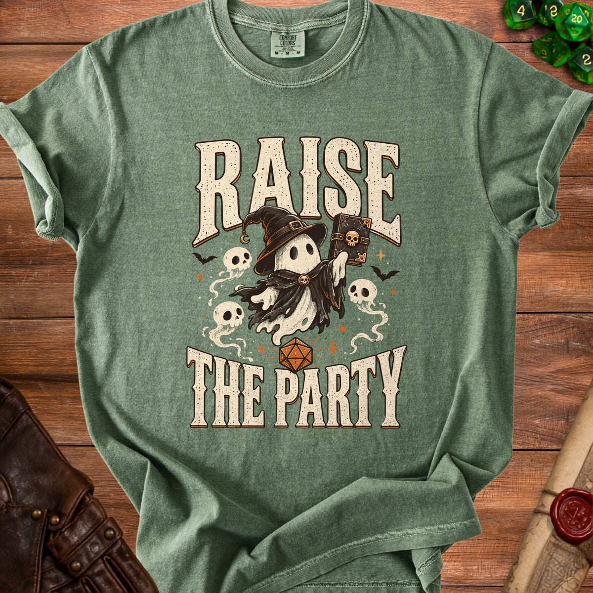 Green t-shirt with ghost holding a book, text "RAISE THE PARTY" and a d20 die.