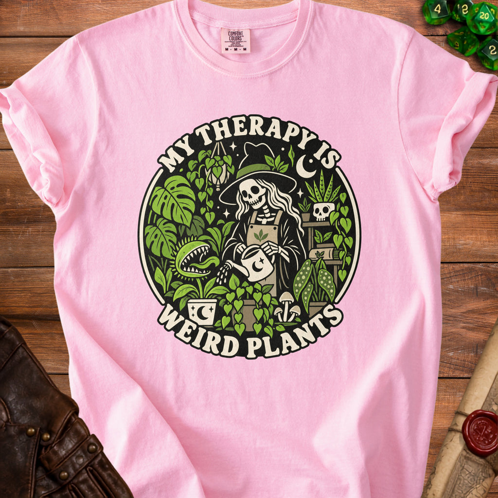 Pink t-shirt with a circular graphic of a skeleton witch watering plants.