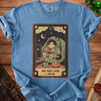 T-shirt featuring a tarot card design of a raccoon playing video games with text.