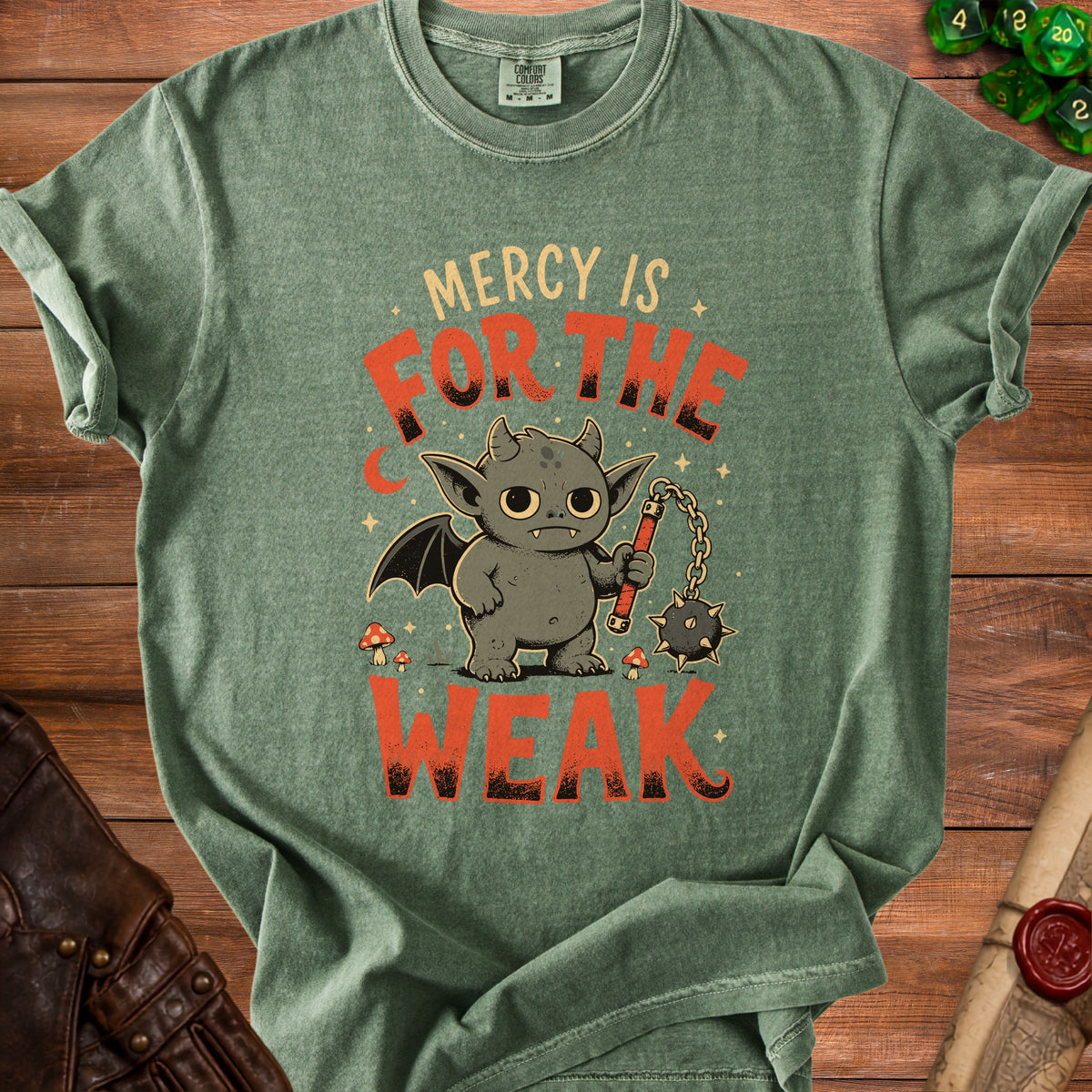 Green t-shirt with a cartoon demon holding a flail, text reads "Mercy is for the weak."