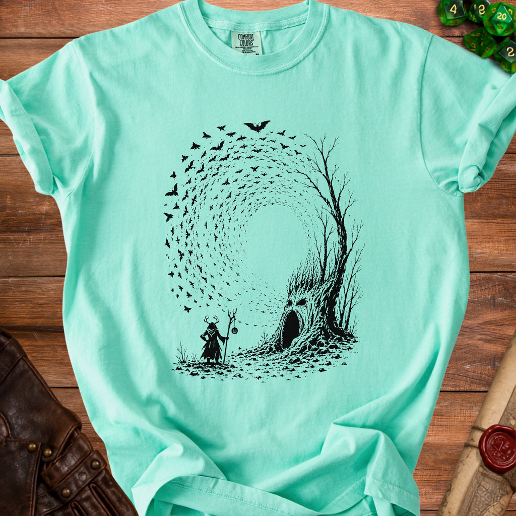 Mint t-shirt with black print of a horned figure and a tree with a face.