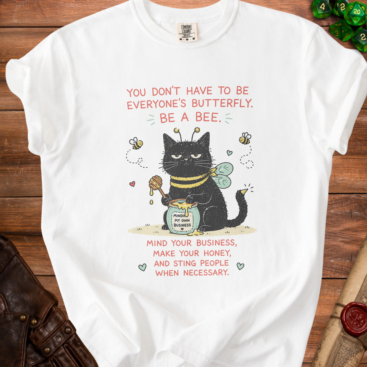 White t-shirt with grumpy bee-cat illustration and text "YOU DON'T HAVE TO BE EVERYONE'S BUTTERFLY. BE A BEE."