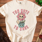 T-shirt with a graphic of a flower with a skull face and the text "TOO CUTE TO CARE".