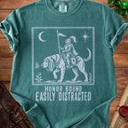 Green t-shirt with a knight on a dog, moon, star, butterfly, and text "HONOR BOUND EASILY DISTRACTED".
