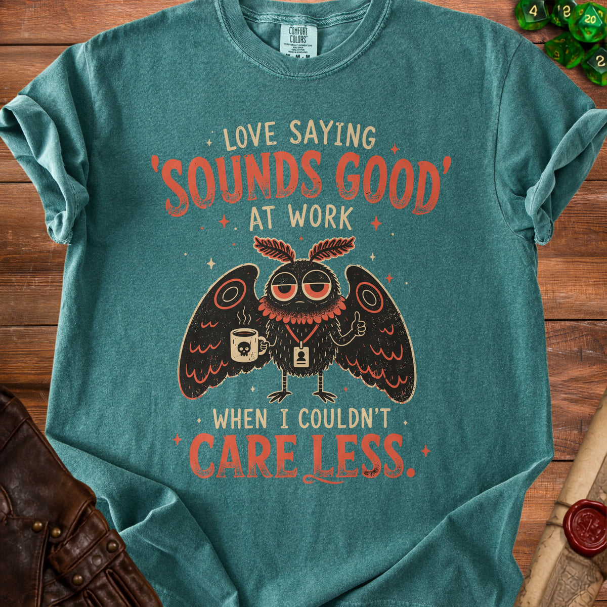 Teal t-shirt with a moth graphic saying "Love saying 'Sounds Good' at work when I couldn't care less."