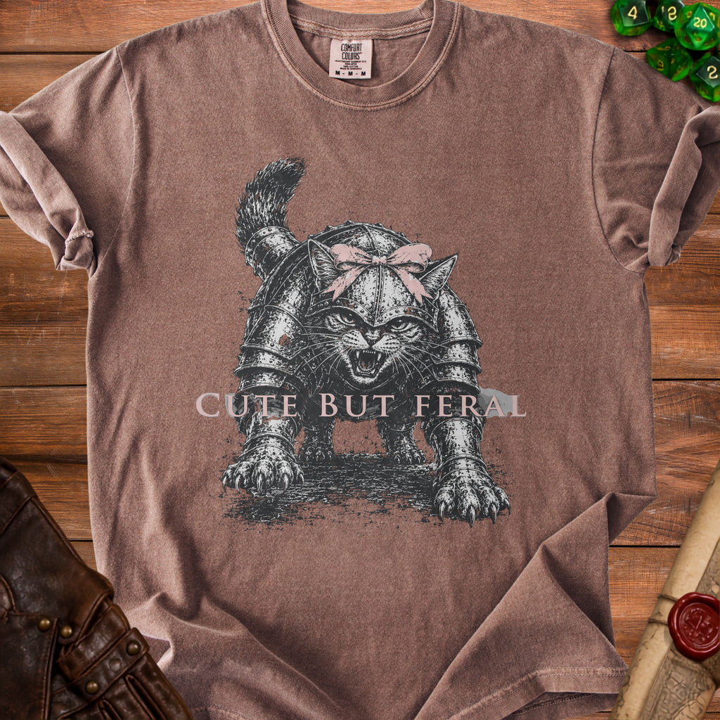 Brown t-shirt featuring a cat in armor with a pink bow and text "CUTE BUT FERAL".
