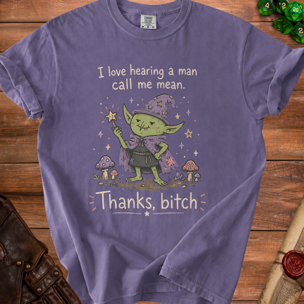 Purple t-shirt with a cartoon goblin witch graphic and text that reads "I love hearing a man call me mean. Thanks, bitch."