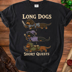 Black t-shirt featuring cartoon dachshunds in knight, wizard, and archer outfits with text "LONG DOGS SHORT QUESTS".