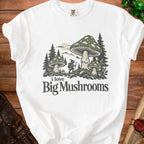 White t-shirt with graphic of a gnome and mushrooms, text "i love Big Mushrooms".