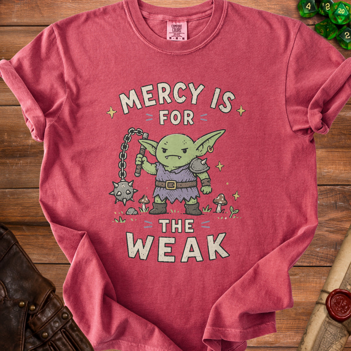 T-shirt with illustration of a goblin holding a flail and text "Mercy is for the weak".