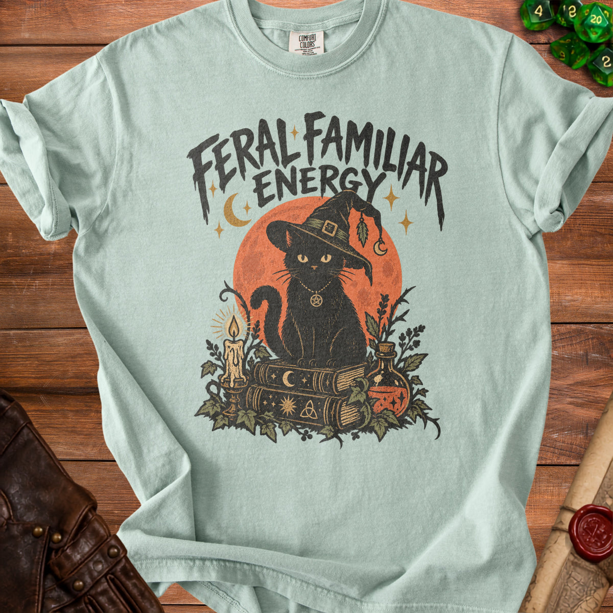 Feral Familiar Energy t-shirt with black cat, books, and potion graphic.