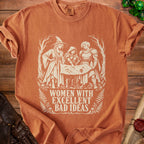 Orange t-shirt with three women planning on a map and the text "WOMEN WITH EXCELLENT BAD IDEAS".