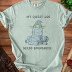 Light green t-shirt with a wizard goblin holding a quest log and the text "MY QUEST LOG NEEDS BOUNDARIES".
