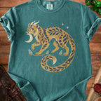 Teal t-shirt with a stylized cat-like creature holding a crescent moon.