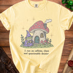 Yellow t-shirt with a frog wizard and mushroom house graphic and text.