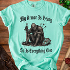 T-shirt with knight sitting, holding sword, and text "My Armor Is Heavy".