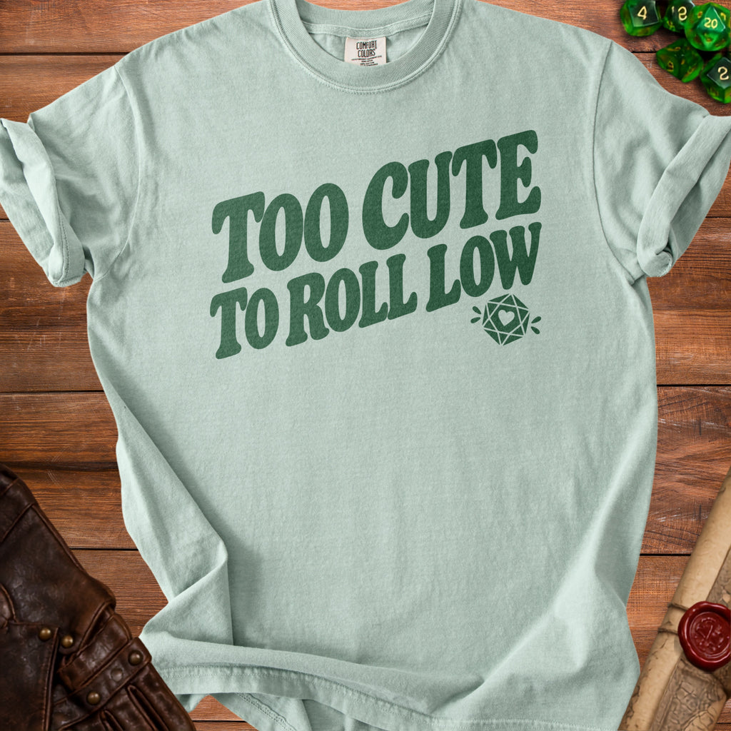 Mint green t-shirt with dark green text "TOO CUTE TO ROLL LOW" and a die.