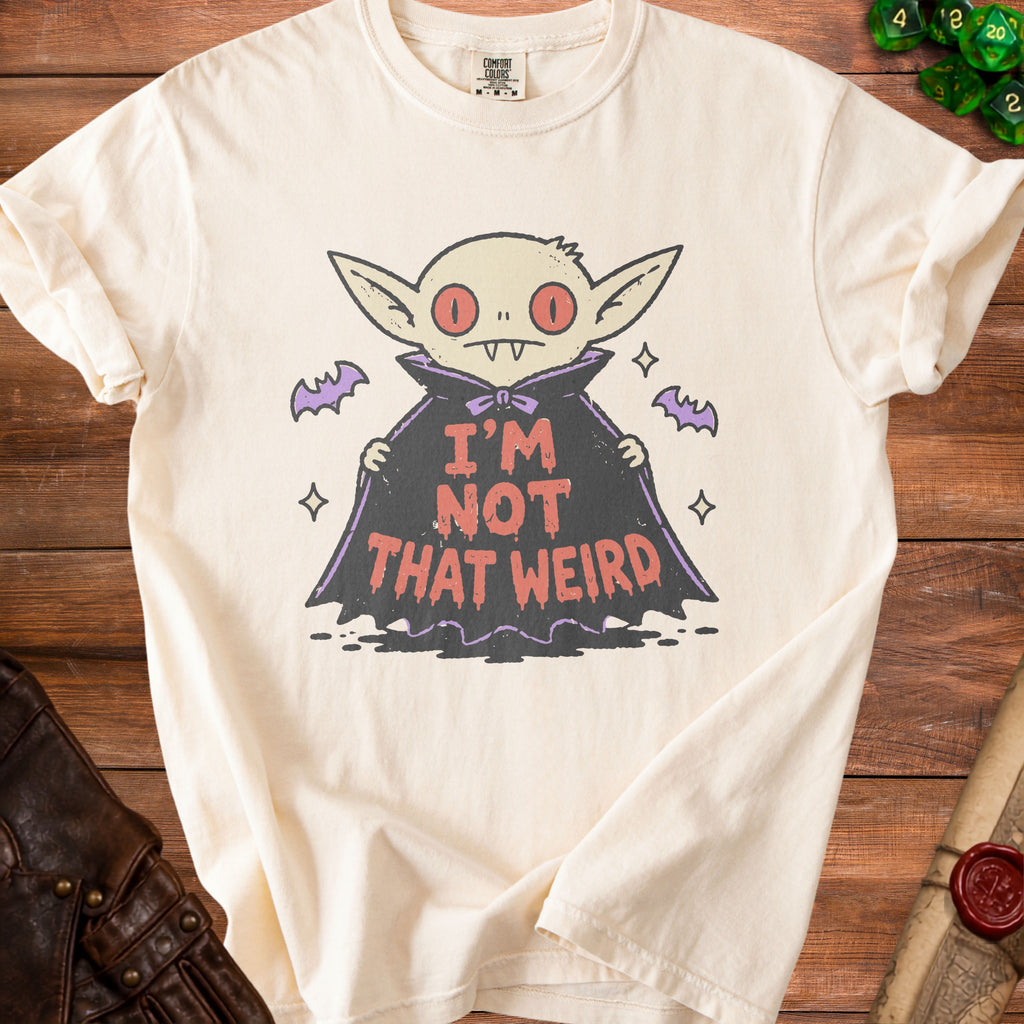 Cream t-shirt with a cartoon vampire graphic that reads "I'm Not That Weird."
