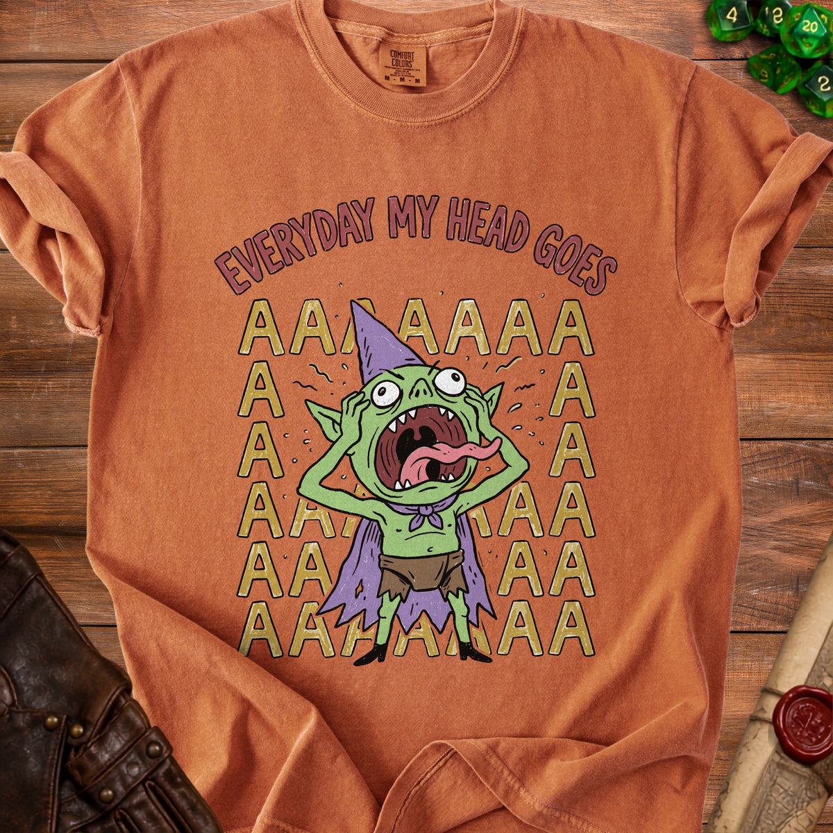 Orange t-shirt with a screaming goblin and text "EVERYDAY MY HEAD GOES".