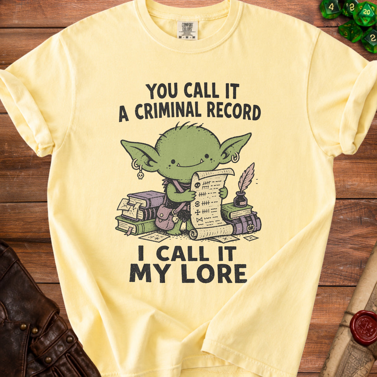 Yellow t-shirt with cartoon goblin holding a scroll, saying "You call it a criminal record, I call it my lore."