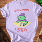Lavender t-shirt with grumpy gnome graphic and text "SURVIVING PURELY OUT OF SPITE".