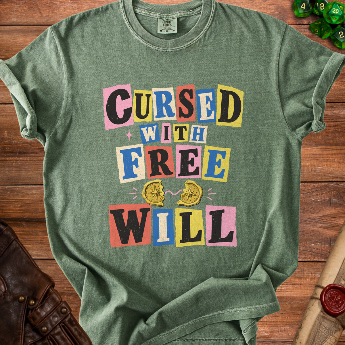 Green t-shirt with "Cursed With Free Will" text and broken compass graphic.