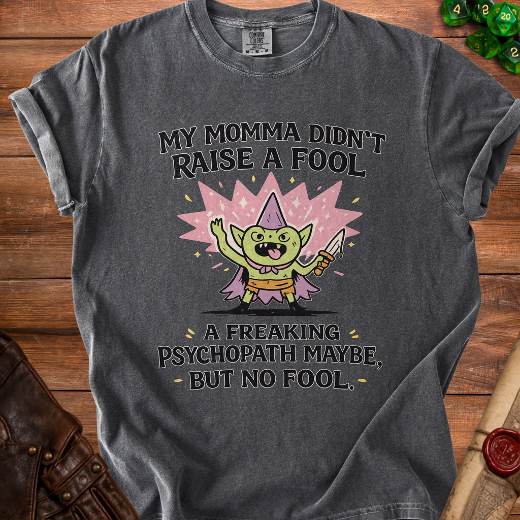 Dark grey t-shirt with a graphic of a goblin holding a knife and the text "My Momma Didn't Raise A Fool".