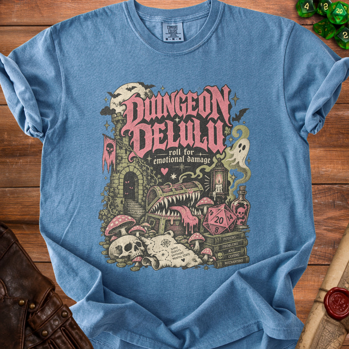 Blue t-shirt with "Dungeon Delulu roll for emotional damage" graphic.