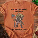 Orange t-shirt with "Under this hard exterior lies a silly lil guy" and illustration.
