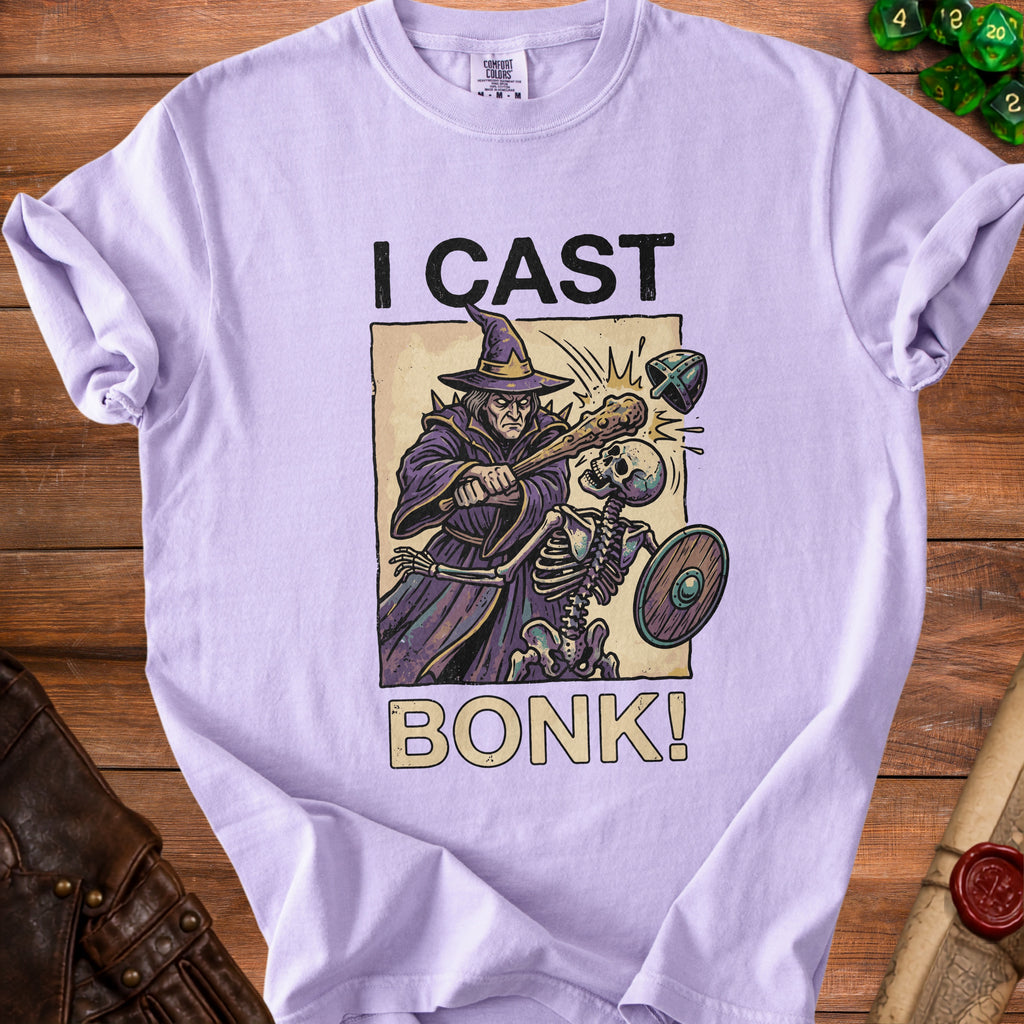Light purple t-shirt with wizard hitting skeleton with club and text "I CAST BONK!"