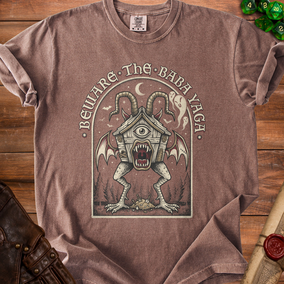 Brown t-shirt with "Beware The Baba Yaga" text and a creature illustration.