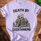 Lilac t-shirt with skeleton graphic and text "Death by Overthinking".