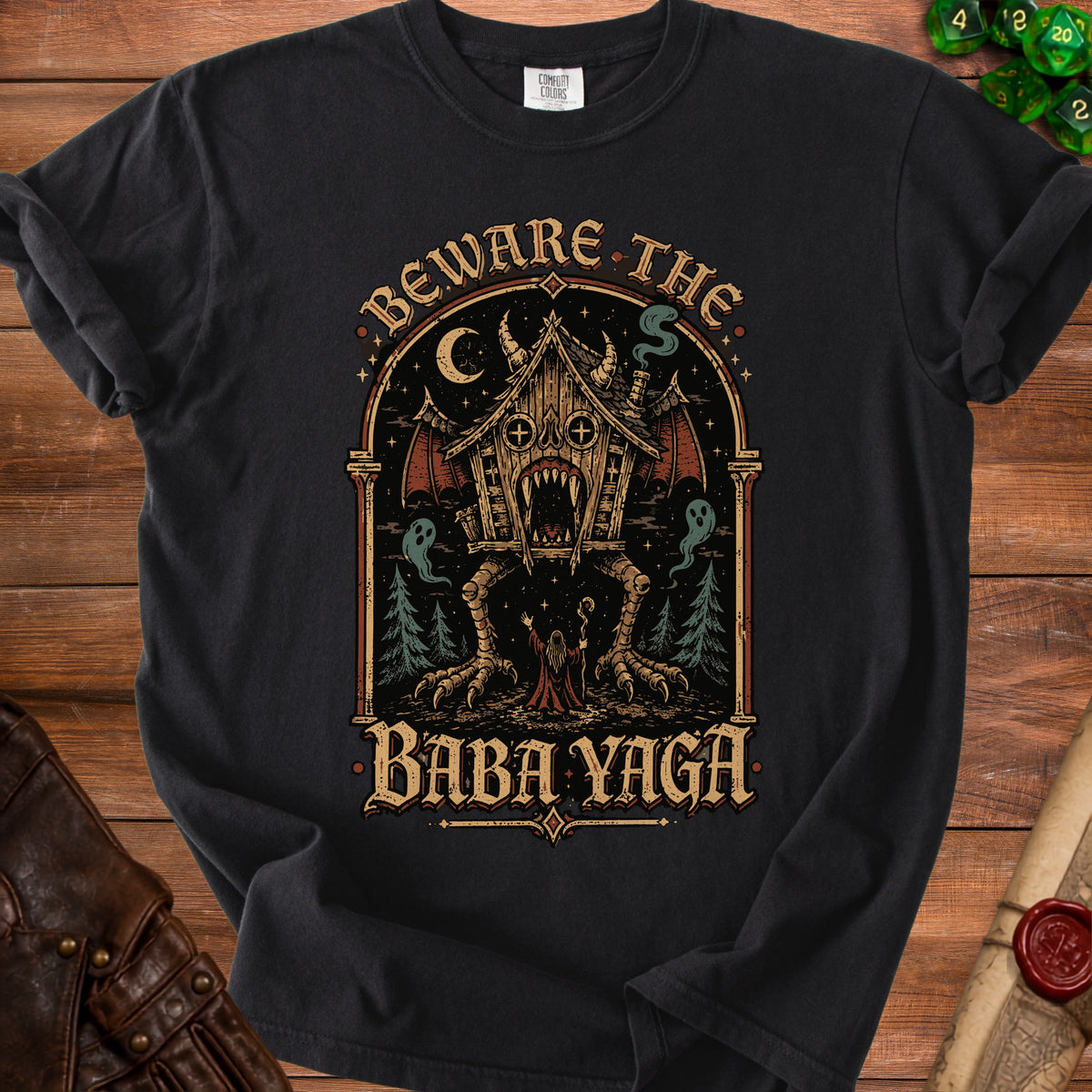 Black t-shirt with "Beware the Baba Yaga" text and spooky cabin graphic.