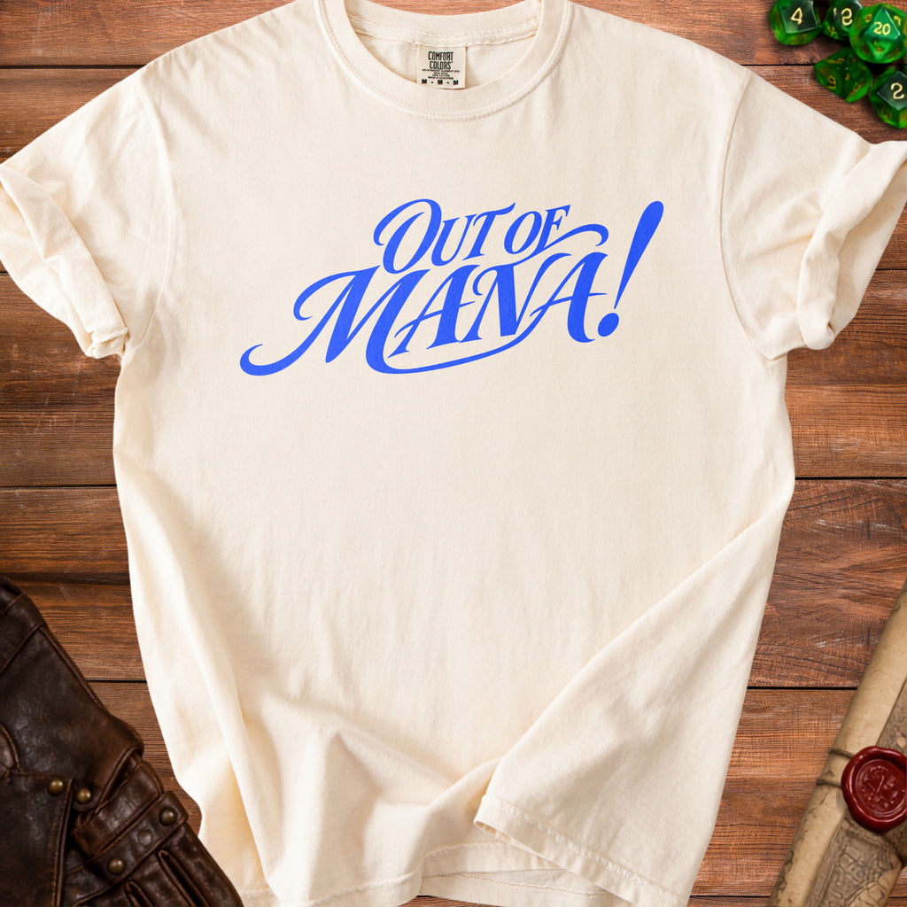 Cream t-shirt with blue "Out of Mana!" graphic, shown on wooden surface.